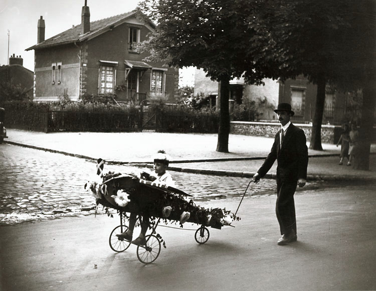 Robert Doisneau - Concours de Chars Fleuris, Choisy le Roi (Man and Boy in Flower Decorated Airplane)